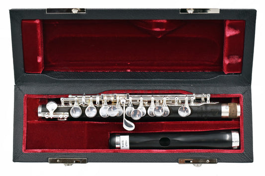 Burkart Legacy Piccolo displayed in an open case with red interior, presenting the piccolo headjoint and body joint 