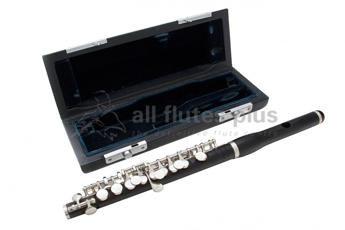 Burkart Professional Model Piccolo displayed in front of its empty case with green lining 