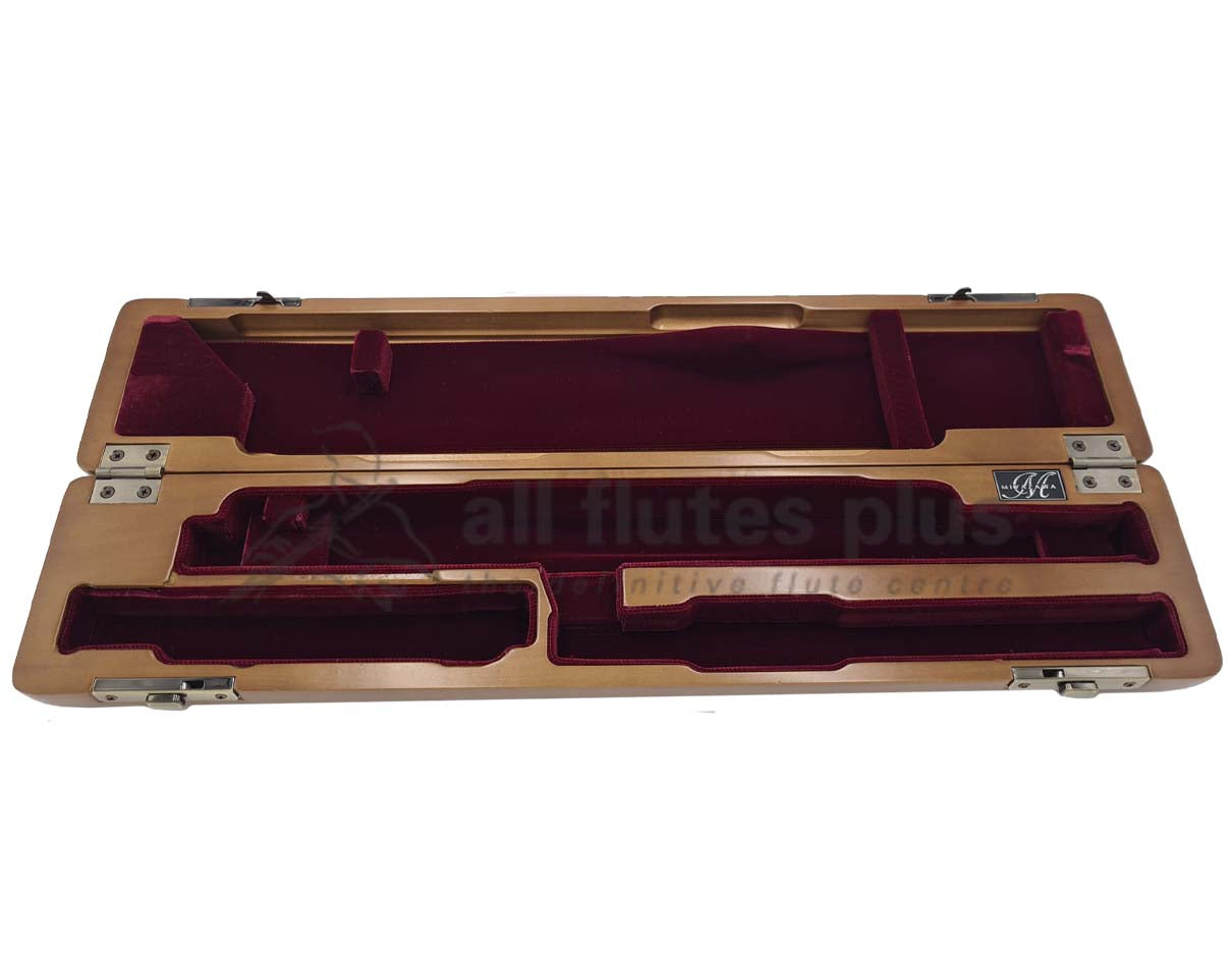 A cherrywood hard case for a flute, featuring a red velvet interior, closed and lying flat.