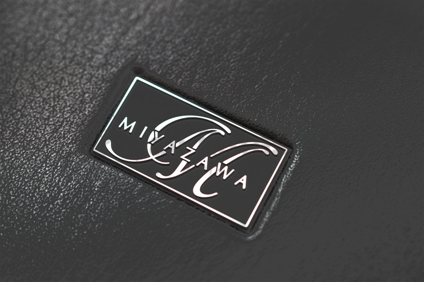 Close up of Miyazawa logo on Miyazawa Faux Leather bound hard case