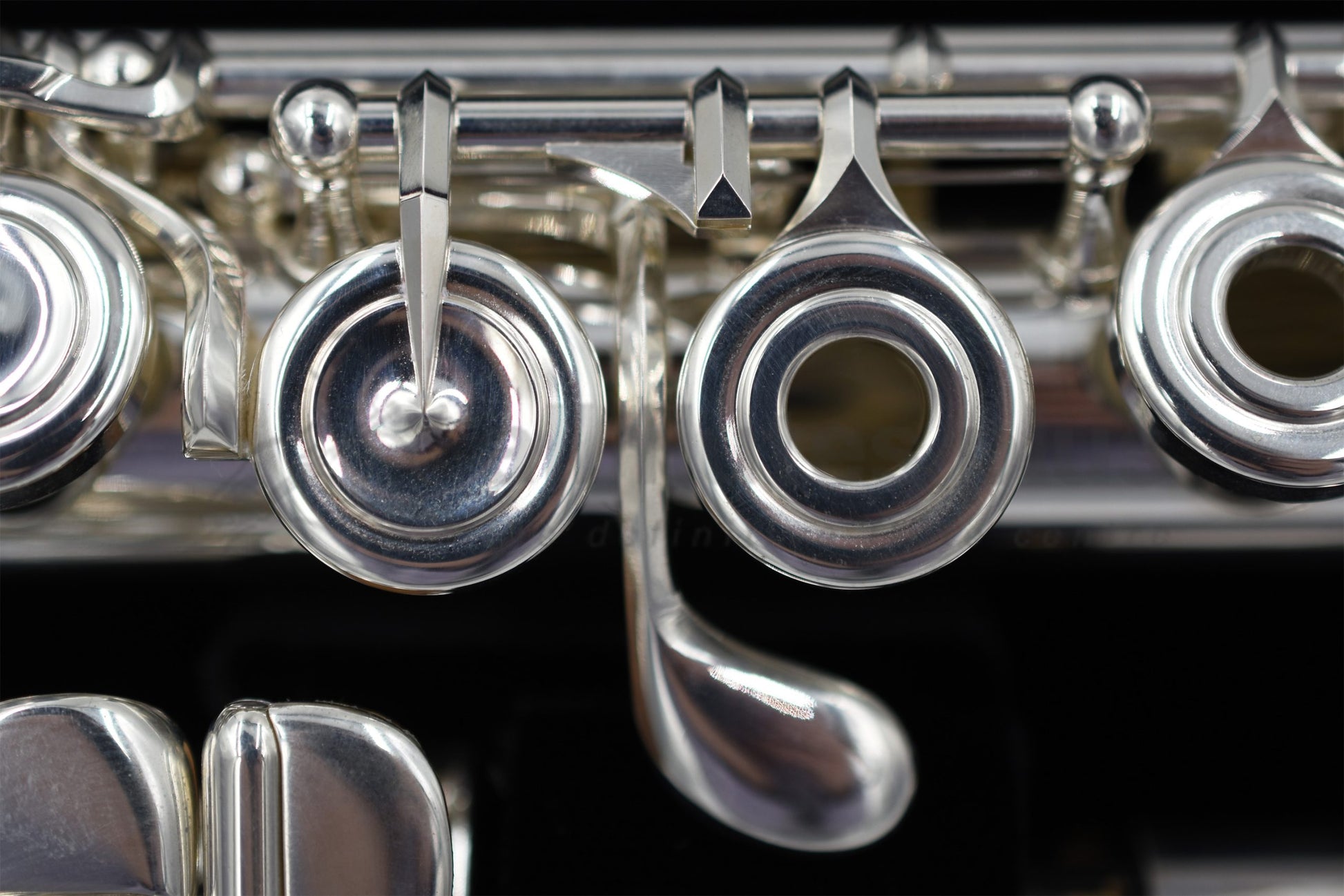 Close up of the G key and E mechanism of a silver Nagahara flute set in the flute case