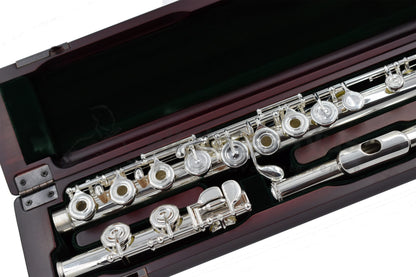 Close up of Pearl PF 695RE Flute set in a cherrywood open case showing body tube and foojoint mechanism