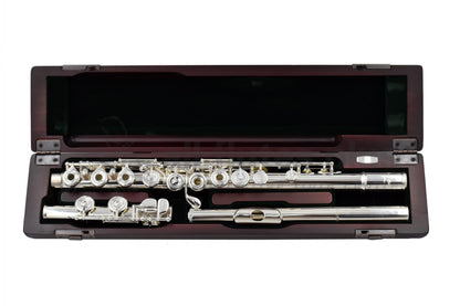 Pearl PF695RE Flute laid out in its open case, silver-plated body, and French-style pointed key-arms, displayed in a cherrywood case.