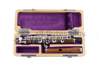 Trevor James Mopane Wood Piccolo displayed in an open case with a purple interior, showing the wood body, silver-plated mechanism, and a Mopane wood headjoint.